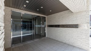 A modern building entrance with glass doors, a brick wall, and a sign reading "HILSSAPPORT". - HILLS SAPPORO 203 (Sapporo)