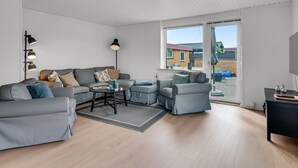 Una sala de estar moderna con un sofá gris, una mesa de centro y una lámpara de pie.