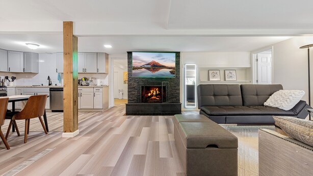 A modern living room with a fireplace, a sofa, and a dining area with chairs. - A Cozy HomeAway Home @Bridle Trail, Bellevue, WA (Bellevue)