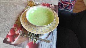 A dining table set with plates, glasses, and cutlery. - Spacious, newly renovated apartment in southern Burgenland with its own balcony! (Oberdrosen)