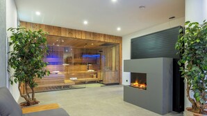 Un salon moderne avec une cheminée, des lambris en bois et des plantes en pot.