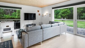 Een moderne woonkamer met een modulaire bank, een flatscreen televisie en een open haard.