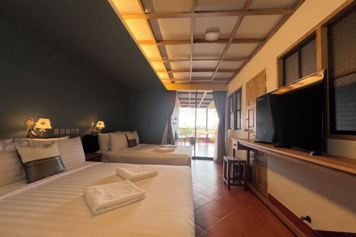 Une chambre d’hôtel avec deux lits, une télévision et une vue sur l’extérieur.