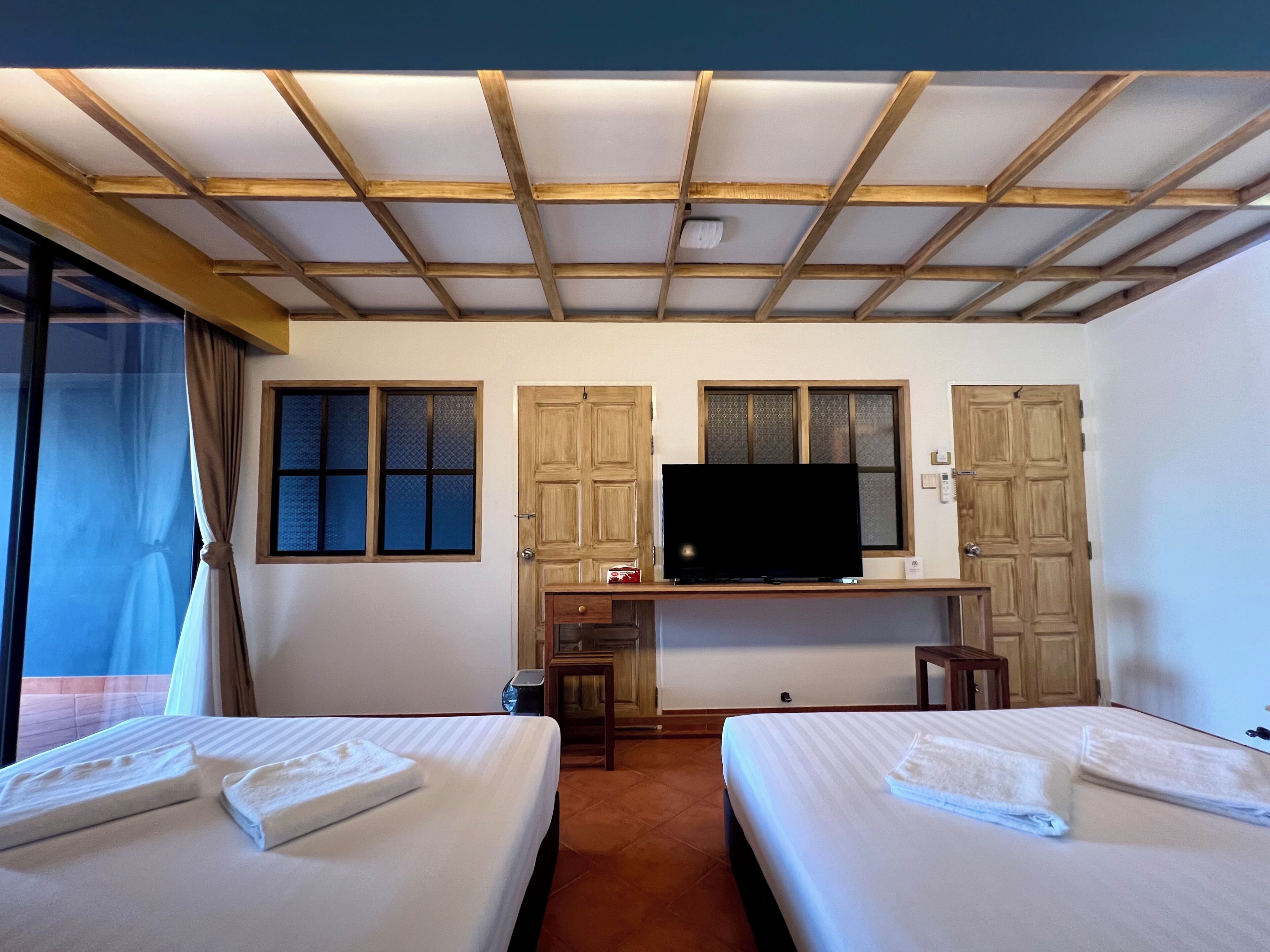 Een hotelkamer met twee bedden, een televisie en een bureau.