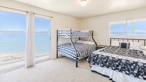 A bedroom with a bunk bed, a large window with a view of the sea, and a ceiling light. - Bear Lake Paradise | Beach + Boat Ramp (Laketown)
