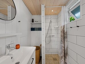 A bathroom with a shower, a sink, a mirror, and a window. - "Terkel" - 800m to the fjord by Interhome (Hemmet)