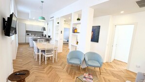 En moderne lejlighed med spiseplads, køkken og opholdsstue.