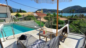 Zona de piscina en la azotea con vistas a un lago y montañas.