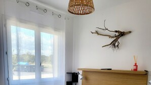 Un lit bien fait, avec une literie blanche et marron, une couverture marron moelleuse et des serviettes blanches pliées.