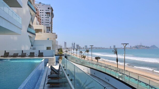 A modern hotel with a pool overlooking a beach and city skyline. - Altomare hermoso depa con vista al mar (Mazatlán)