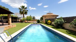 A rectangular swimming pool with a stone wall and a palm tree in the background. - Incredible & Unique Costa Dorada Abode! (Creixell)