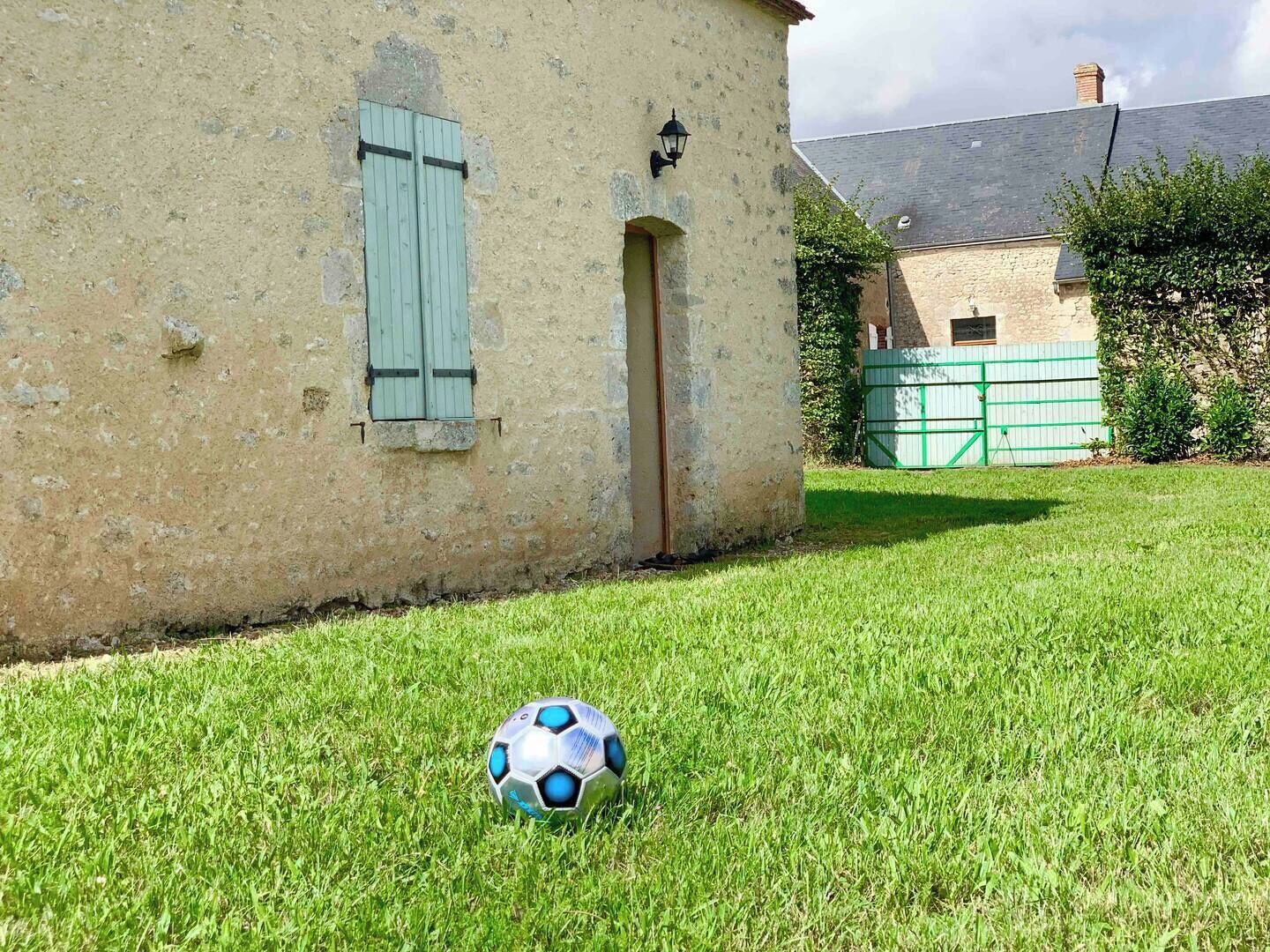 Ein Haus mit einem Rasen und einem Fußball im Vordergrund.
