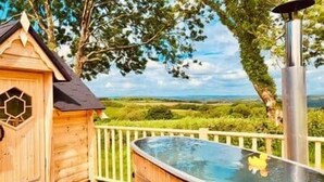 A wooden cabin with a hot tub and a view of the countryside. - Stairway to Devon - Tarka Cabin (Umberleigh)