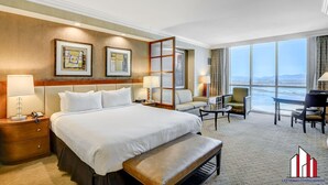 A hotel room with a large bed, a desk, a sofa, and a view of the city. - MGM Signature- Lazy River Jacuzzi Work Desk Studio (Las Vegas)