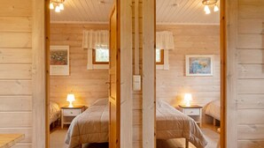 A mirrored room with two beds, wooden floors, and ceiling lights. - Lonnakko by Interhome (Kittilä)