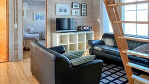 A cozy living room with a wooden interior, a TV, and a ladder. - Lonnakko by Interhome (Kittilä)
