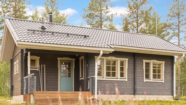 A single-story house with a dark wooden exterior, a tiled roof, and a front porch with a bench. - Lonnakko by Interhome (Kittilä)