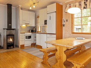 A kitchen with white cabinets, a wooden table, and a bench. - Lonnakko by Interhome (Kittilä)