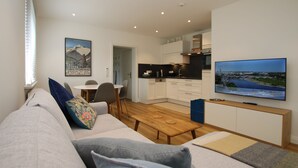 Una sala de estar moderna con sofá, mesa de centro y televisor de pantalla plana.