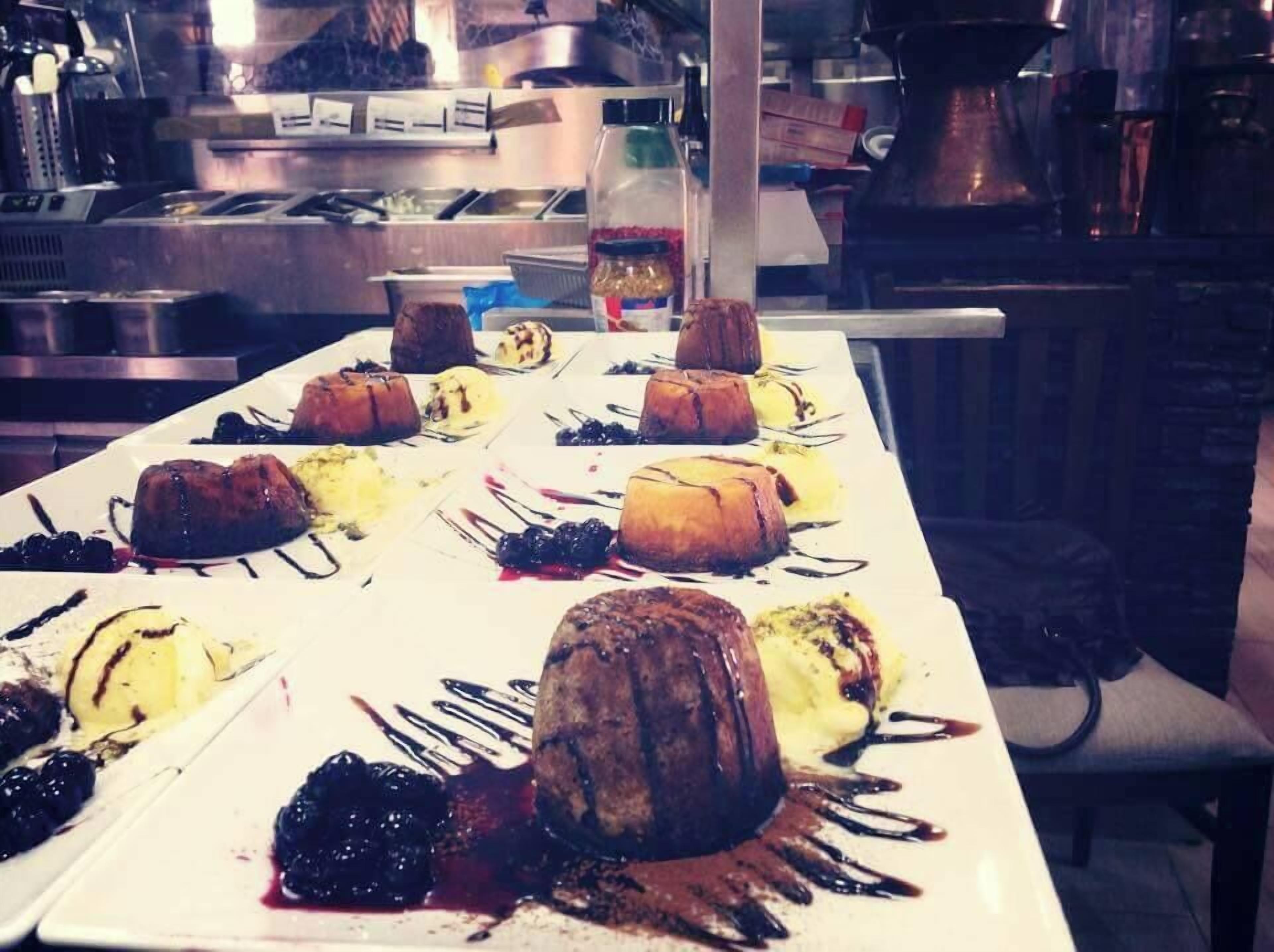 Ein Dessertbuffet mit verschiedenen Kuchen und Gebäck auf einem langen weißen Tisch.