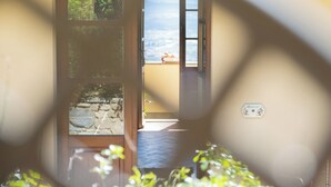A doorway leading to a balcony with a stone wall and a sign on the wall. - Agriturismo Cima alla Serra (Buti)
