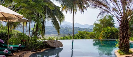Una piscina al aire libre, sombrillas, tumbonas