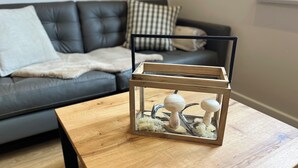 Een houten tafel met een glazen terrarium met decoratieve paddenstoelen.