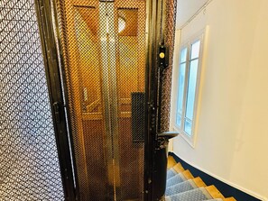 Staircase leads to an upper floor, flanked by light-colored walls and a window.