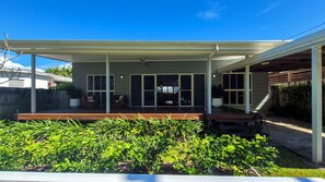 A covered patio area with a seating arrangement and a view of the backyard. - Jalun Bayun – Beachfront Holiday Accommodation in Newell Beach (Newell)