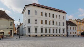 A historic building with a symmetrical facade, multiple windows, and a central entrance.