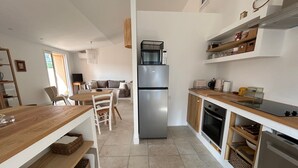 A modern kitchen with a central island, built-in oven, and a refrigerator. - Renovated T3 House in Collioure, 2 Bedrooms, Balcony (Collioure)
