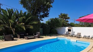 A swimming pool with lounge chairs and a white wall in the background. - Beautiful villa with pool in quiet area in Saint-Jean-de-Monts (Saint-Jean-de-Monts)