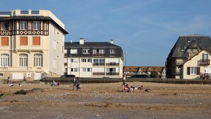 A coastal building with a traditional architectural style, featuring multiple windows and balconies.