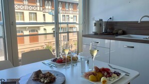 A dining table with a variety of food, wine glasses, and a wooden cutting board.