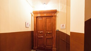 A wooden double door with a doormat featuring a letter 'R'. - Relais Ammira (Naples)