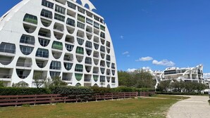 A modern building with a unique architectural design, featuring a series of balconies and large windows.
