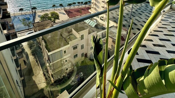 A balcony with a view of the sea and buildings. - Hotel Britania  (Vlorë)