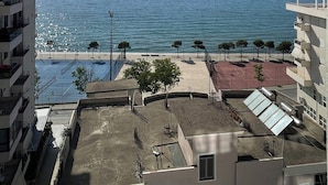 A high-rise building with a view of the sea and a person paragliding in the distance. - Hotel Britania  (Vlorë)