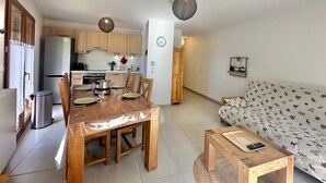 Un espace de vie compact comprenant un coin repas, une kitchenette et un canapé.