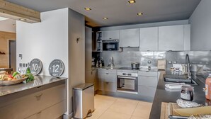 Een moderne keuken met roestvrijstalen apparatuur, een houten aanrecht en een afvalbak.