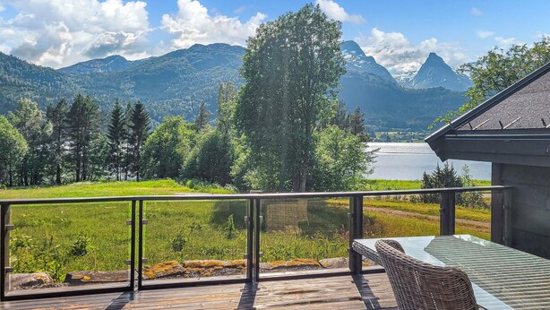 A deck with a glass railing overlooking a mountainous landscape and a lake. - Nice home in Folkestad with sauna (Folkestad)