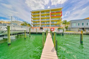 Un hotel de varios pisos con balcones, un muelle y un puerto deportivo.