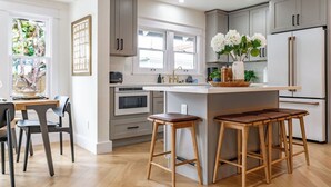 A modern kitchen with a central island, bar stools, and a refrigerator. - Stunning-5 Bed-Close To Zoo, Balboa Park, Downtown (San Diego)