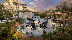 Un jardin avec une piscine, un espace salon extérieur et une pergola.