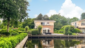 A residential building with a small patio and a water canal in front. - 3 bedroom stunning home in Workum (Workum)