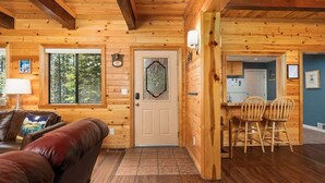 A log cabin interior with a living room, dining area, and kitchen. - Black Diamond | Family & Pet-Friendly Cabin Near Huntington Lake (Big Creek)