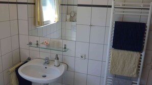 A bathroom with a white sink, mirror, and towel rack. - Gästehaus Hasenkath am Deich, Gästezimmer, Bed&bike. Radwandern, Familenurlaub (Kleve)