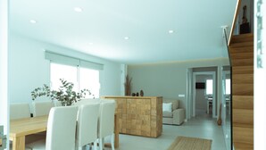 A modern interior with a dining area, a wooden accent wall, and a staircase.