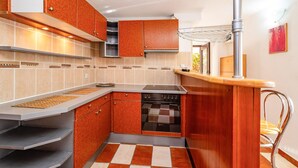 Uma cozinha moderna com forno embutido, eletrodomésticos de aço inoxidável e um backsplash de azulejos quadriculados.