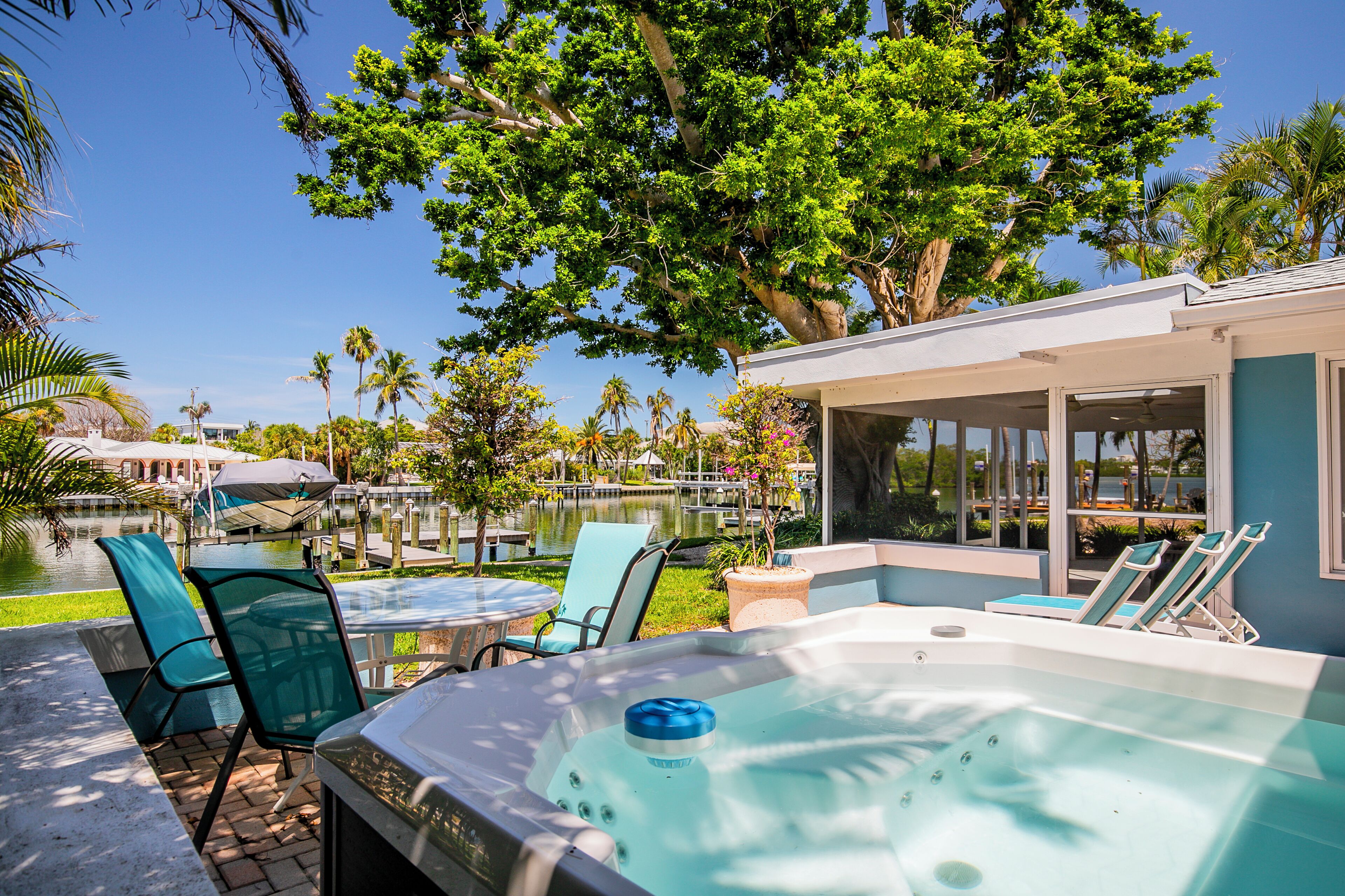 Un espace avec un bain à remous, des chaises et une vue sur un lac.